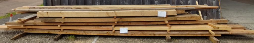 Stack of long structural softwood beams in assorted sections